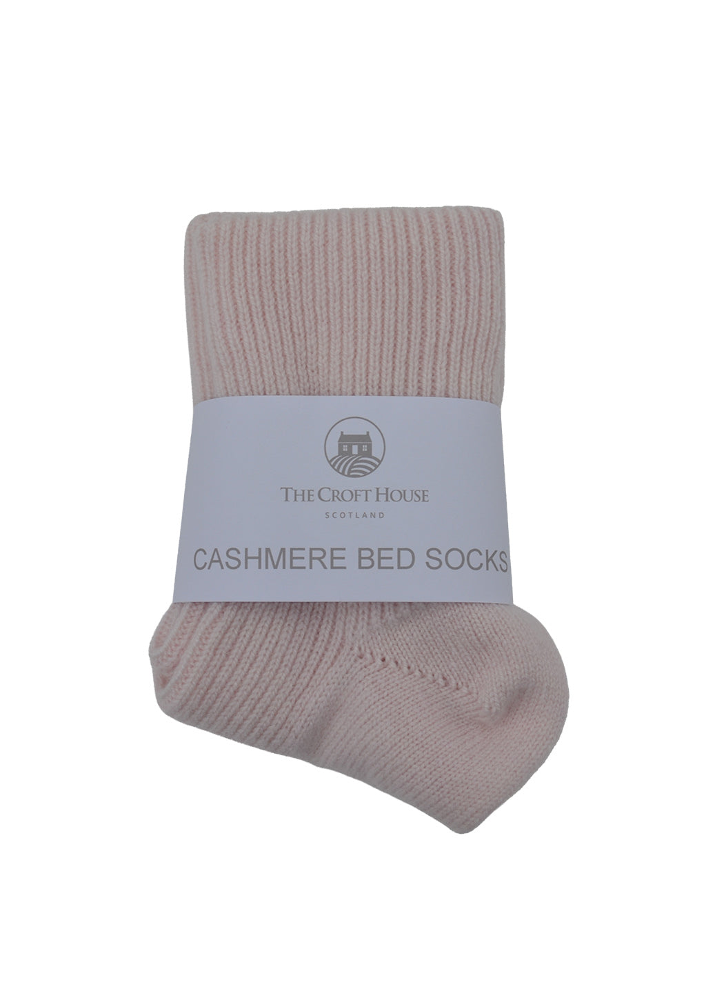 A pair of folded light pink cashmere  bed socks with white packaging band on a white background