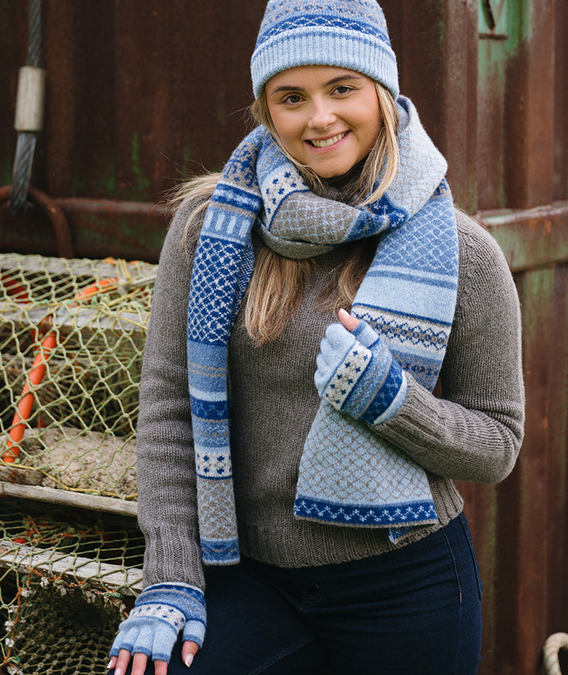 girl wearing pale blue wool fairisle fingerless gloves with matching hat and scarf