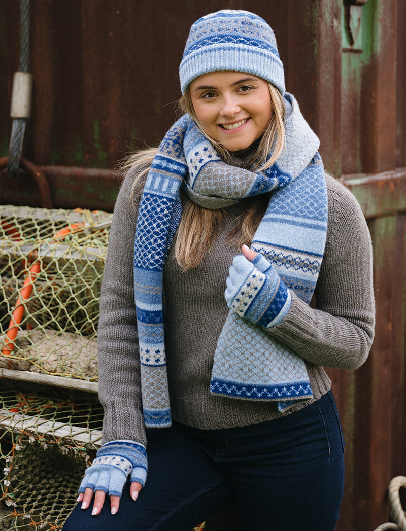girl wearing pale blue wool fairisle fingerless gloves with matching hat and scarf