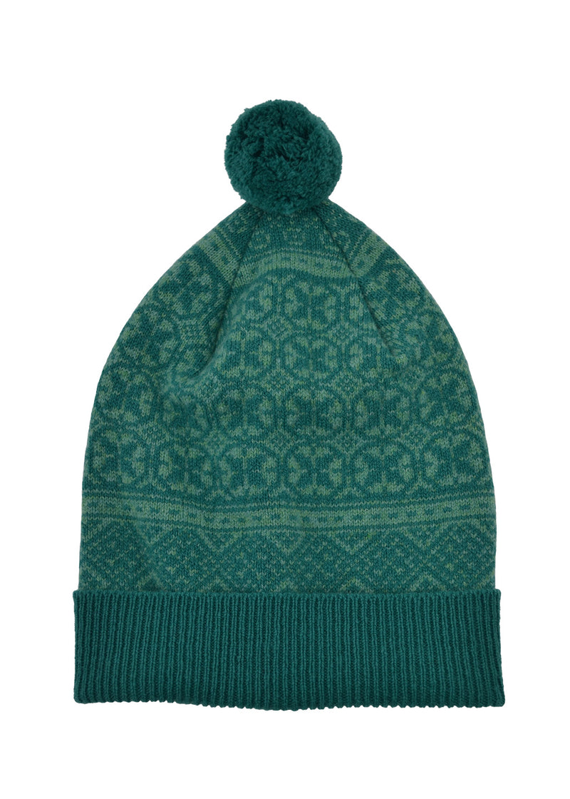 A sea green knit beanie hat with a matching pom-pom on top, featuring a Fair Isle pattern and a ribbed cuff, shown against a plain white background.